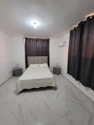a bedroom with a bed and two night stands at Departamento Luna en Santo Domingo in Santo Domingo