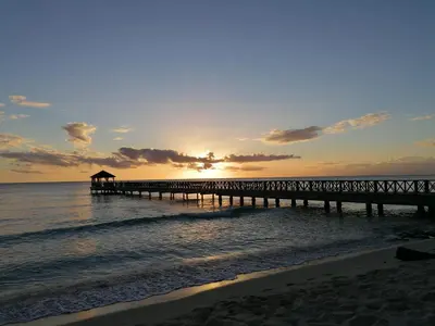 a pier stretches out into the ocean at sunset at Caribbean Star - Estrella Dominicus Bayahibe in Bayahibe