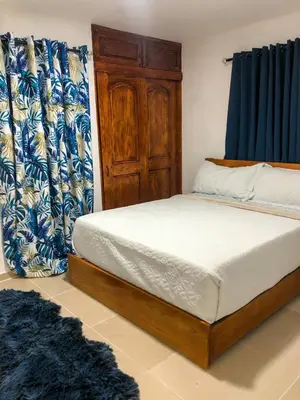 a bedroom with a bed with blue and white curtains at Ocean View Apart. In Down town in San Felipe de Puerto Plata