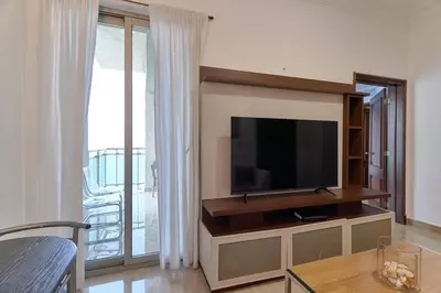 a living room with a flat screen tv on a wall at Luxurious Ocean View Suite in Santo Domingo