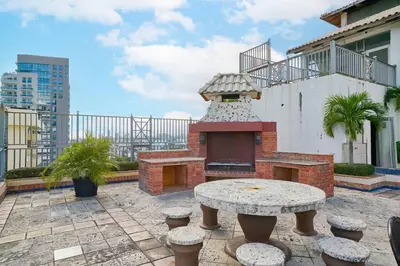 a patio with a table and a pizza oven at Luxurious Ocean View Suite in Santo Domingo
