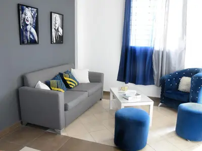 a living room with a couch and blue chairs at las carreras centro D la ciudad in Santiago de los Caballeros