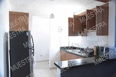 a kitchen with a black refrigerator and wooden cabinets at las carreras centro D la ciudad in Santiago de los Caballeros