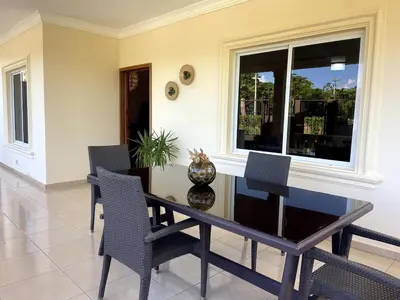 a dining room with a table and chairs and a window at Casa Canephora in Las Galeras