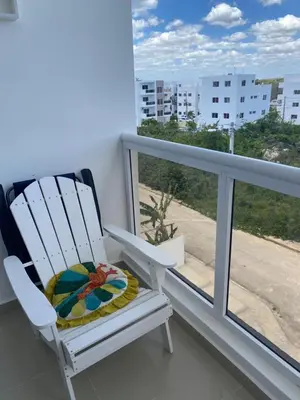 a white rocking chair sitting on a balcony with a window at Bridget Place in Bayahibe