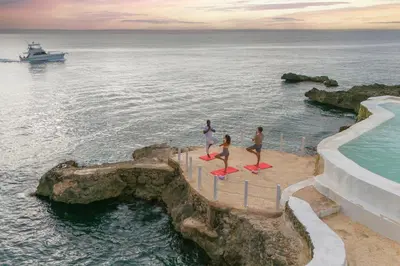a group of people standing on surfboards near the ocean at Hotel HM Alma de Bayahibe - Adults Only - All Inclusive in Bayahibe