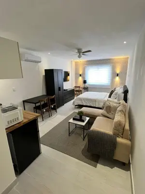 a living room with a bed and a couch at Suites By SalcedO in Santo Domingo