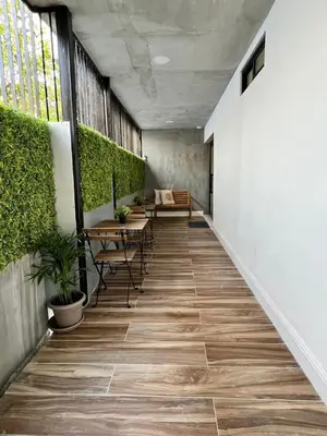 a hallway with tables and chairs and plants at Suites By SalcedO in Santo Domingo