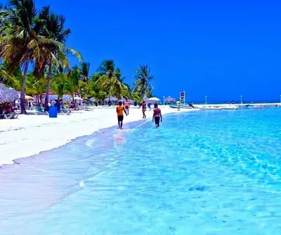 a group of people walking on the beach at Suites By SalcedO in Santo Domingo