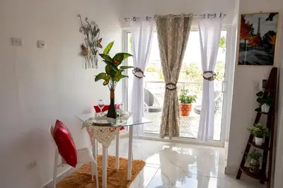 a dining room with a glass table and a window at Royal Terrace V (Duque) in San Felipe de Puerto Plata