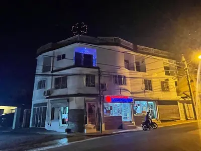 a building on a street at night with a person on a bike at Royal Terrace IV (King) in San Felipe de Puerto Plata