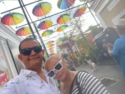 a man and a woman posing for a picture under umbrellas at Royal Terrace I (Queen ) in San Felipe de Puerto Plata